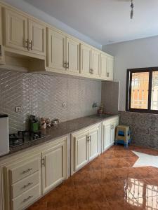een keuken met witte kasten en een tegelvloer bij La casa d’ourika in Ourika