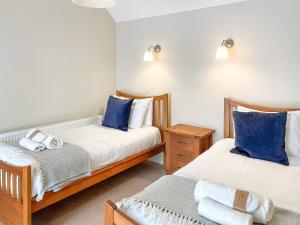 a bedroom with two beds with blue pillows at Brandy Cottage - Ukc6855 in Millton of Clova