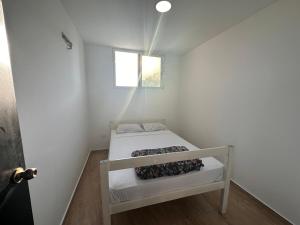 Habitación blanca pequeña con cama. en Apartament KC, en Salinas