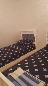 Schlafzimmer mit einem Bett mit einer schwarzen und weißen Bettdecke in der Unterkunft Apartment in Nador in Nador