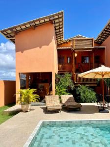 a house with a swimming pool in front of a house at Pousada Vila dos Corais - Taipu de Fora in Marau