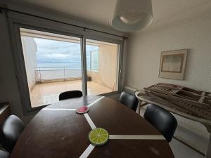 a dining room with a table and a large window at Appartement Les Sables-d'Olonne, 3 pièces, 4 personnes - FR-1-197-207 in Les Sables-d'Olonne