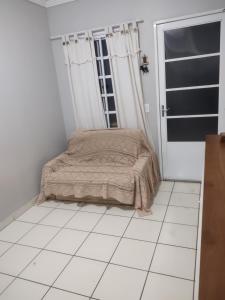 a bedroom with a bed on a white tiled floor at Casa RibeirãoPreto in Ribeirão Preto