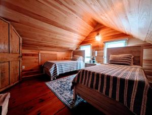 een slaapkamer met 2 bedden in een houten hut bij Oceanside Saltwater Cottage NEW in Milbridge