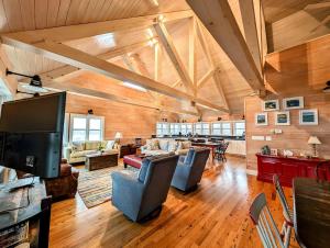 a living room with couches and a flat screen tv at Oceanside Saltwater Farm House NEW in Milbridge