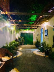 a patio with a green gate and plants at night at Casa Tuia Holiday Flat a 2km do centro e das falesias da Praia de Morro Branco in Beberibe +58 photos