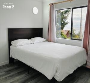 a bed in a bedroom with a large window at Westview Centre Motel in Powell River