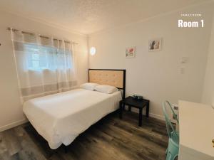 Dormitorio pequeño con cama y mesa en Westview Centre Motel en Powell River