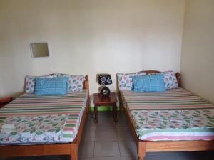 A bed or beds in a room at Calitang Pearl Cottage