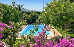basen w ogrodzie z fioletowymi kwiatami w obiekcie Beautiful Home In Chiaramonte Gulfi With Wifi w mieście Chiaramonte Gulfi