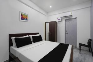 a bedroom with a bed and a chair and a door at OYO ARN RESIDENCY in Chennai