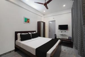 a bedroom with a large bed with a ceiling fan at OYO ARN RESIDENCY in Chennai