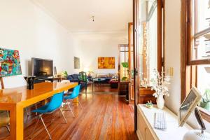 a living room with a wooden table and blue chairs at Gran suite en Palermo in Buenos Aires