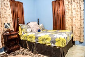 a bedroom with a bed and a table and curtains at Comfort, suite Vacation home in Montego Bay