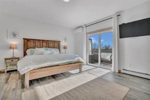 um quarto com uma cama grande e uma porta de vidro deslizante em Ocean View West Duplex with Walk to Crescent Beach em Owls Head