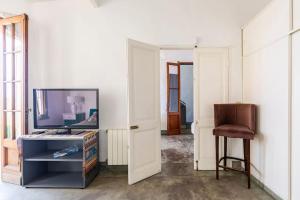 a living room with a television and a stool at Gran suite en Palermo in Buenos Aires +9 photos
