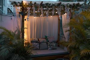 a pergola with a couch on a patio with plants at Mi casita lounge - Imbanaco in Cali