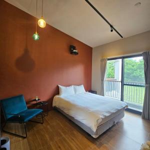 sypialnia z łóżkiem, krzesłem i oknem w obiekcie 自然野奢精品旅宿 w mieście Ruisui