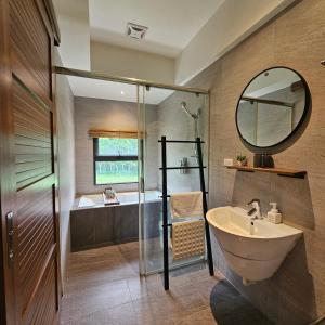 W łazience znajduje się umywalka, prysznic i lustro. w obiekcie 自然野奢精品旅宿 w mieście Ruisui