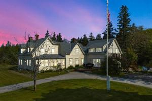 une grande maison arborant un drapeau américain devant elle dans l'établissement Seaside Serenity Farmhouse, à Saint George