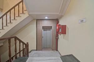 a hallway with stairs and a red fire extinguisher at OYO Kiran Palace in Jaipur