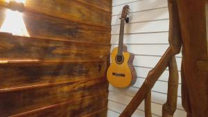 a guitar is hanging on a wall at Dins Nature Villa in Elgiriya
