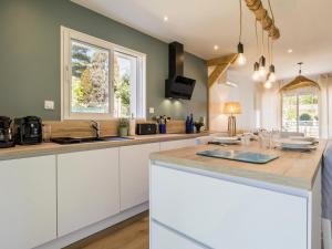 a kitchen with white cabinets and a counter top at Maison rénovée 2023 à 300m de la mer avec terrasse, jardin clos, clim et wifi - FR-1-306-1270 in Saint-Brevin-les-Pins +7 photos