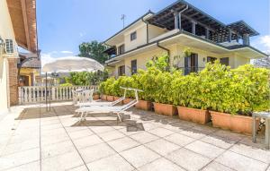 un patio con un banco frente a una casa en Stunning Home In Bosconero With Kitchen, 