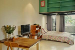 um quarto com uma cama e uma secretária com uma televisão em Bu Studio Hồ Hoàn Kiếm em Hanói