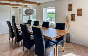 a dining room with a wooden table and black chairs at Gorgeous Home In Nordborg With Kitchen in Nordborg