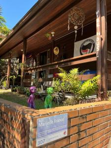 dos estatuillas sentadas frente a un edificio en Vibe House Hostel, en Florianópolis