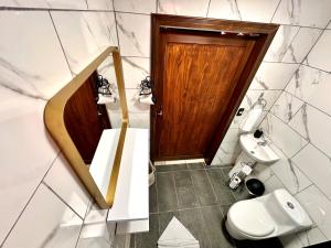 łazienka z toaletą i drewnianymi drzwiami w obiekcie Retiro Arenal w mieście Fortuna