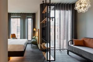 a hotel room with a bed and a room with a bed and a living room at Moxy Warsaw Praga in Warsaw