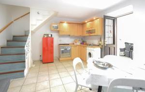 uma cozinha com um frigorífico vermelho e uma mesa em 1 Bedroom Pet Friendly Home In Baveno em Baveno