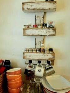 a kitchen with a shelf with dishes on it at Porta del Sol ~Less than 1 m to center of town! in San Germán