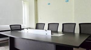 una sala de reuniones con mesa y sillas en ALTEA HOTEL - San Bartolo, en San Bartolo