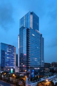a tall glass building in a city at night at Changsha Zealandia Serviced Apartment in Changsha