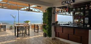 un restaurante con un bar con vistas al océano en ALTEA HOTEL - San Bartolo, en San Bartolo