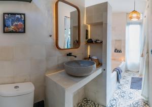 een badkamer met een wastafel en een spiegel bij Cozy, Smart, Renovated Flat to Western Standard in Ubud