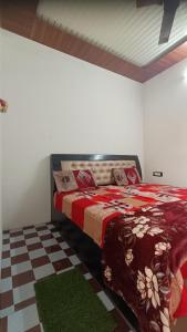 a bedroom with a bed with a red blanket at Keshav Narayan Home Stay in Mathura
