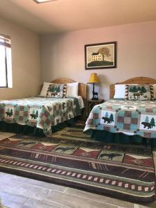 a bedroom with two beds and a rug at Big Bear Lake Front Lodge in Big Bear Lake
