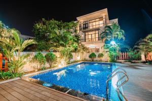 a house with a swimming pool at night at FLC Grand Villa BT35.06 in Sầm Sơn
