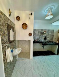 a bathroom with a sink and a mirror at AFRICA SURF HOUSE in Taghazout
