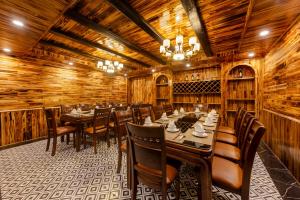 uma sala de jantar com paredes e mesas e cadeiras de madeira em Sapa Soleil Hotel em Sapa