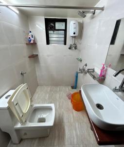 a white bathroom with a sink and a toilet at Red Velvet Villa in Kīhīm