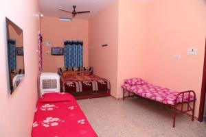- une chambre avec 2 lits et un banc dans l'établissement SURUkuttyYATRA, à Rameswaram