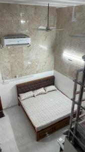 uma pequena cama num quarto com um chuveiro em Duplex Room Stay at Hill View em Tiruvannamalai