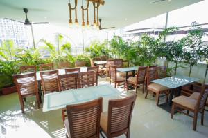 Hotel Skylink Hospitality Next to Amber Imperial في مومباي: مطعم بالطاولات والكراسي والنباتات