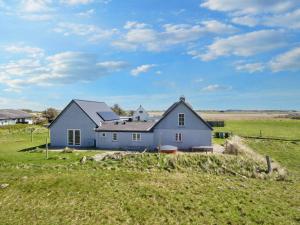 a blue house in the middle of a field at 10 person holiday home in Harboøre-By Traum in Harboør