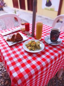una mesa de cuadros roja y blanca con comida y bebida en hotel Suyay Lodge Tarapoto, en Tarapoto